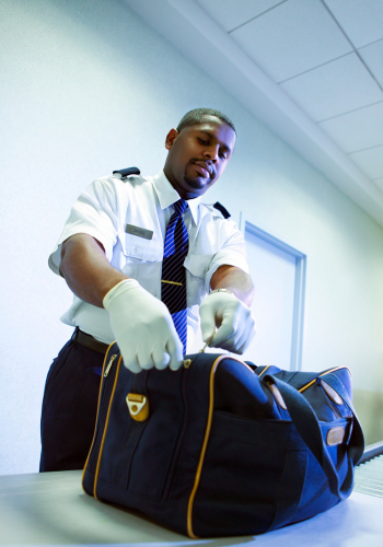 fouille de sécurité d'un bagage dans un aéroport
