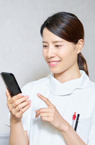 Description de la photo : personnel médical échangeant en visio avec un smartphone